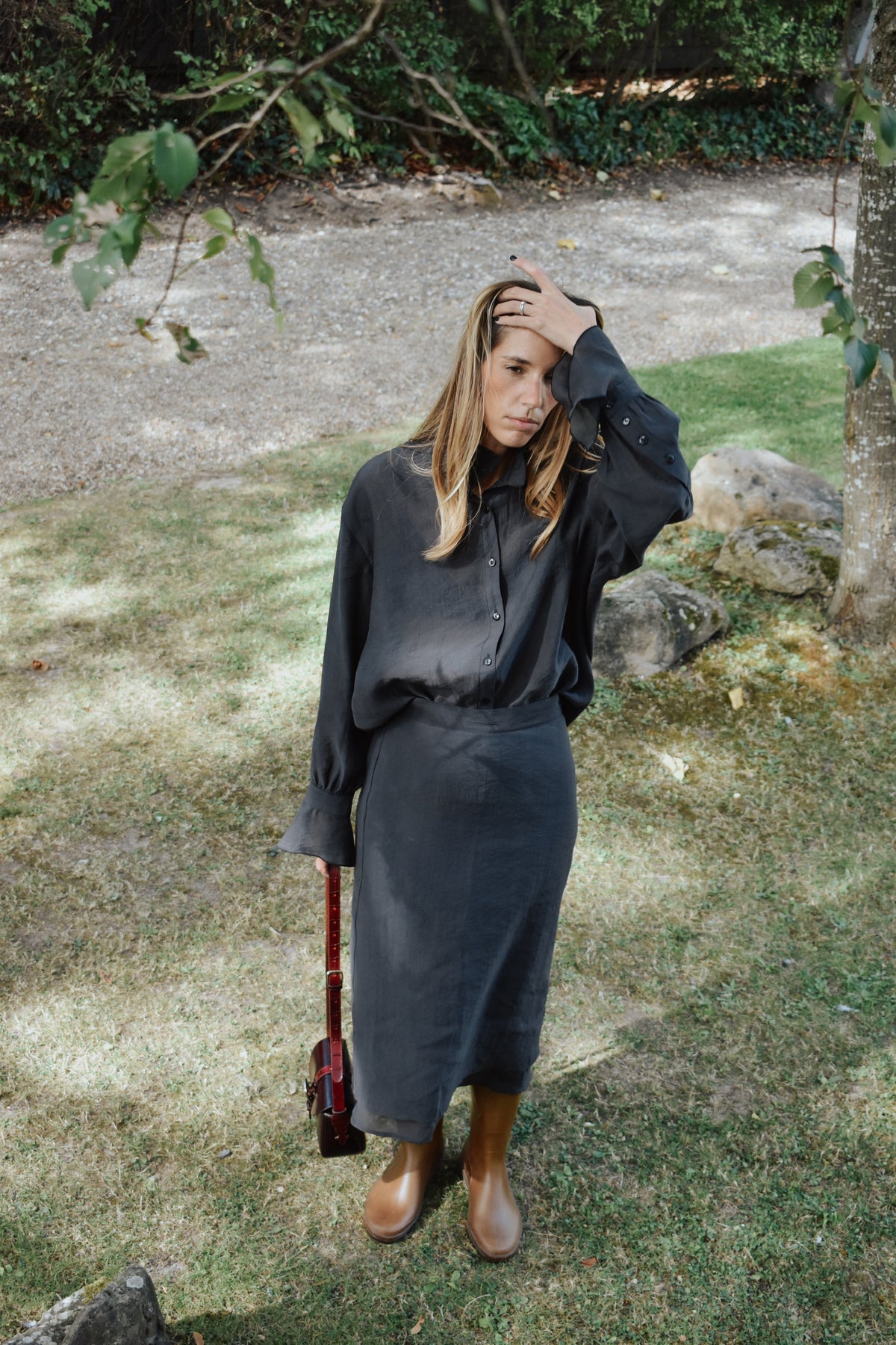 Jupe Ninon anthracite portée avec chemise assortie, look femme en extérieur